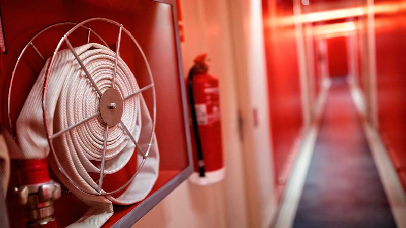 Средства пожаротушения на стене: пожарный шкаф, огнетушитель. 