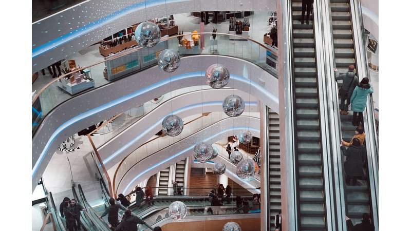 Эскалатор торгово-развлекательного центра с посетителями, вид сверху